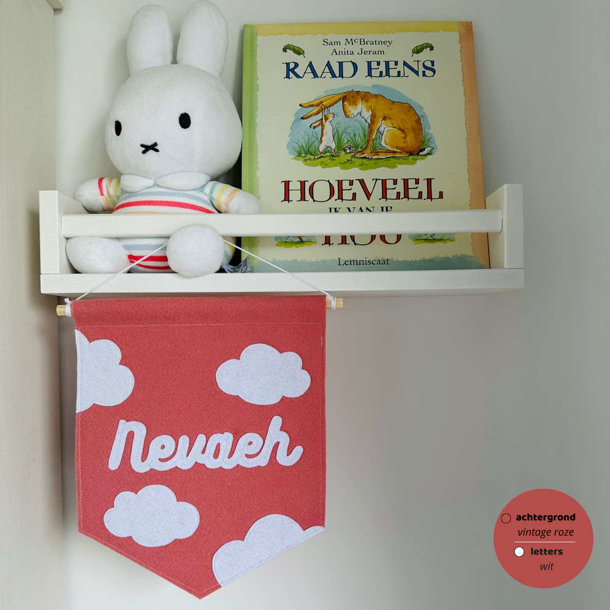 Gepersonaliseerde handgemaakte vilten banner met de naam "Nevaeh", bestaande uit oud roze kleurige banner met witte vilten letters wolken iconen. De randen van de banner is afgewerkt met een rechte rand. De banner hangt aan een wit katoenen koord aan een houten stok in een 
