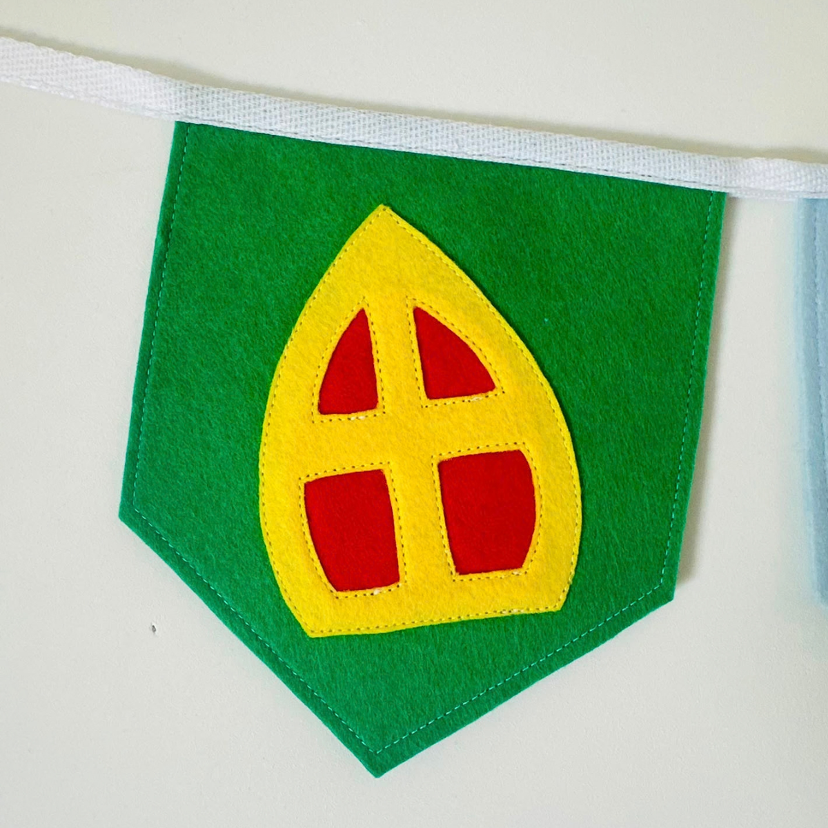 Vilten vlaggetje met gele mijter met rood kruis op een groen vlaggetje, onderdeel van de Sinterklaas vlaggenlijn WELKOM